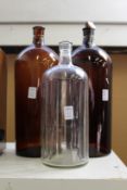 Two large amber glass chemist jars and a similar clear glass jar.