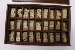 A mahogany box containing a spelling alphabet, the lid opening to reveal numerous compartments