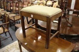 A George III mahogany stool.