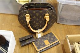 A designer style handbag with matching accessories to include purse and wallet.