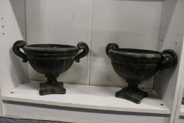 A pair of green patinated pottery urns.