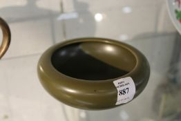 A green ground circular porcelain brush washer.