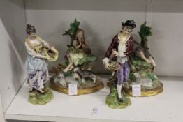 Two pairs of decorative porcelain figure groups.