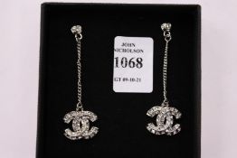 A pair of decorative silver earrings.