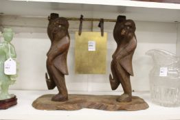 An unusual dinner gong, the gong carried by a pair of carved wood monkeys.