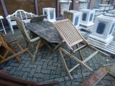 A garden table and four folding armchairs.