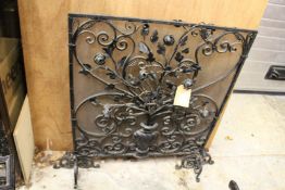 An ornate wrought iron fireguard.