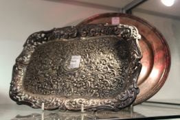 A silver embossed decorated dressing table tray and a circular sterling silver tray.