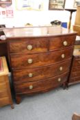 A large mahogany bow front chest of drawers.