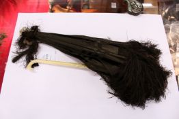 A small ivory handled folding parasol.