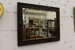 A carved wood wall mirror.