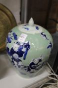 A Chinese green Celadon bulbous shaped jar and cover painted with children.