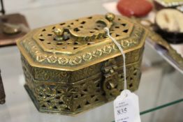 An eastern brass box with pierced decoration and hinged lid.