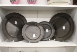 A group of four early pewter plates, the two smaller plates with touch marks for William De Jersey.