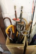 A collection of walking sticks, umbrellas, fencing foils.
