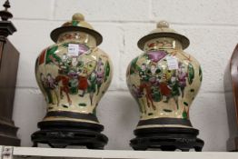 A pair of Chinese crackle glazed ginger jars and covers on hardwood stands.