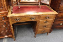 An Edwardian oak single pedestal desk.