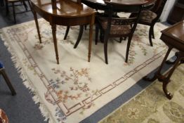 A large cream ground Chinese carpet.