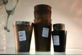 A quantity of horn beakers, one with a silver rim.