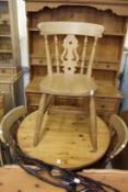 A pine circular kitchen table and three chairs together with a pine oval table top.