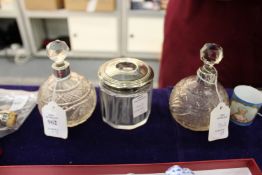 A pair of cut glass and silver scent bottles and a silver mounted hair tidy.
