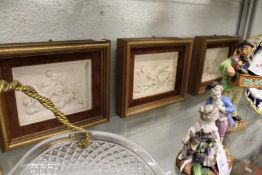 A set of three classical style plaques with gilt frames.