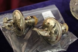 A pair of novelty bottle stoppers.