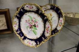 Two late 19th century floral decorated plates, each with blue and gilt borders decorated with floral