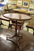 A mahogany oval tripod table.