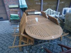 An extending garden table with six chairs and a parasol.