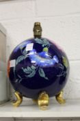 A floral decorated globe shaped lamp base.
