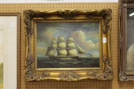 A decorative picture depicting a Man O' War in full sail, in a decorative gilt frame.