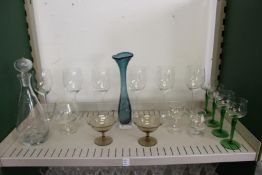 A modern glass decanter, a stylish glass vase and other glassware.