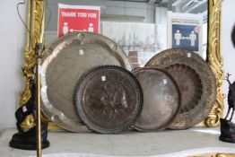 Four large eastern brass trays.