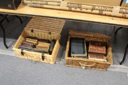 Two baskets containing leather bound prize bindings and other books.