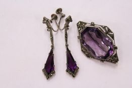 An Art Deco style brooch set with an amethyst coloured stone together with a pair of matching drop