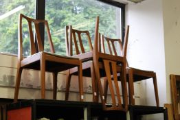 A set of four stylish teak dining chairs.