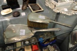A silver backed hand mirror and matching brush.
