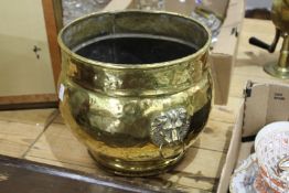 A brass coal bucket with lion mask handles.