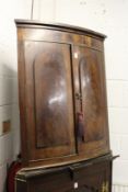 A 19th century mahogany bowfront two door hanging corner cupboard.