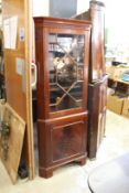 A mahogany standing corner cabinet.
