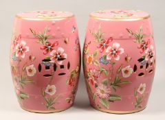 A PAIR OF CHINESE PORCELAIN BARREL SEATS, pink ground decorated with butterfiles and flowers 18ins