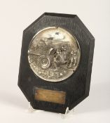 A GERMAN PRESENTATION PLAQUE with a plated cast metal roundel depicting soldiers firing a field gun,