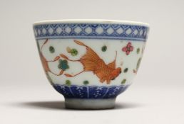 A CHINESE PORCELAIN TEA BOWL decorated with fish. Signed, mark in blue 3ins diameter.