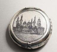 A RUSSIAN NIELLO CIRCULAR SNUFF BOX with a scene of Moscow. 2.5ins diameter.