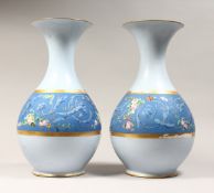 A LARGE PAIR OF CONTINENTAL LIGHT BLUE BULBOUS VASES, painted with a deep blue hand with flowers