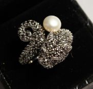 A SILVER AND MARCASITE PANTHER AND PEARL RING