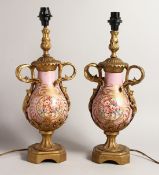 A GOOD PAIR OF 19TH CENTURY FRENCH PORCELAIN AND ORMOLU TWO HANDLED URNS, converted to lamps,