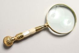 A MAGNIFYING GLASS with mother of pearl and gilt handle