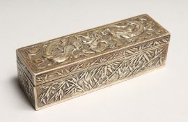 A CHINESE SILVER LONG BOX AND COVER repousse with dragons. 5ins long.